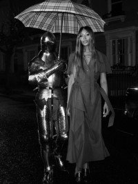 Naomi Campbell wearing Burberry Trench Dress with Equestrian Knight holding an Umbrella 