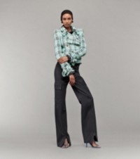 Modelo que luce chaqueta a cuadros Burberry Check, pantalones cargo con detalle de cremalleras y sandalias Ronda