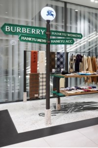 Display of Burberry products hanging on a clothing rack and folded on shelves