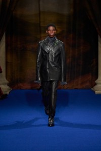 Alex Kosi wearing leather tailored jacket and trousers, with Burberry Check boots