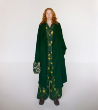 Model wearing the silk trench coat, pyjama shirt and trousers in ivy, with EKD perforated rubber mules in poison.