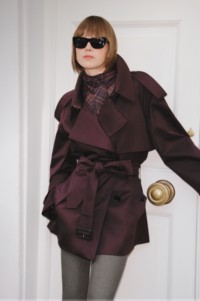 Shot of model wearing Short Gabardine Fitzrovia Trench Coat in colour Red Wine with Burberry Check Scarf