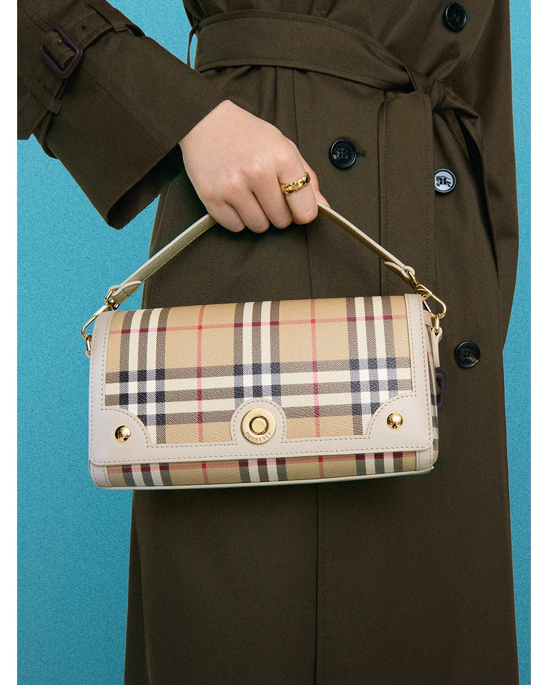 Shot of model wearing the Top Handle Note Bag​ in colour Vintage check/soap beige