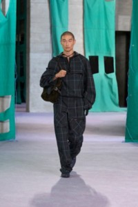 Model in Anorak aus Seidenviskose im Burberry Check-Karomuster und Cargohose in den Farben Seaweed und Inox