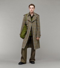 Modello che indossa un trench in Burberry Check con una camicia da rugby in jersey a righe e pantaloni in denim