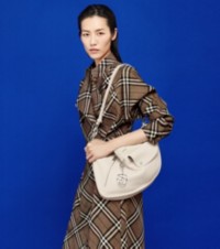 Modelo usando um vestido trench em xadrez Burberry Check com mules de couro e uma bolsa Shield média