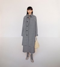 Model wearing the Houndstooth car coat and silk hooded dress, styled with Gold-plated shield earrings and leather Baby pumps in pebble.