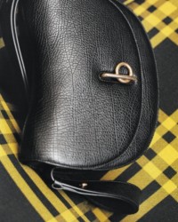 Mittelgroße Tasche „Rocking Horse“ in Schwarz vor gelbem Hintergrund mit Karomuster