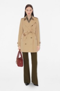 La mujer lleva un trench coat Heritage Chelsea corto.