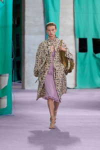 Model wearing daisy print viscose blend zip car coat in eccles and ruffled ribbed silk dress in wisteria.