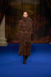 Kai Isaih Jamal wearing Alpaca wool scarf dress in biscuit beige, leather Cavalier boots in treacle brown, paired with leather belt in purple and check leather gloves in truffle brown.