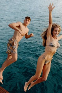 Photo de mannequins sautant dans la mer, vêtus de maillots de bain Burberry Check