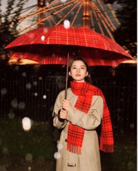 Chinesische Schauspielerin Jingyi Zhang in einem Burberry-Trenchcoat mit einem roten Schal im Burberry Check-Karomuster