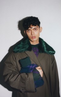 Winter 2023 Campaign featuring a model holding the Check Wool Hot Water Bottle in Vine