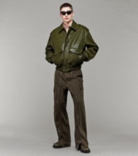 Modelo que luce chaqueta en piel tono mire y pantalones cargo color enebro