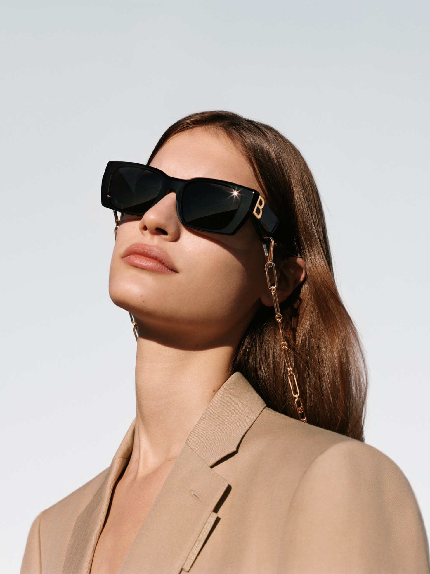 model wearing black square frames with chain