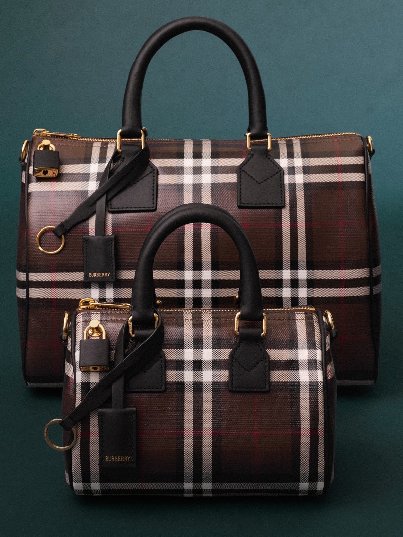 Two Burberry check-pattern bowling bags in different sizes displayed against a teal background.