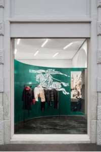 Window display of Burberry products hanging on a clothing rack