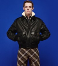 Model in schwarzer Lederjacke, Hemd aus Popelin und eleganter Hose im Burberry Check-Karomuster