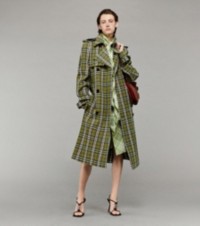 Modelo usando trench coat e vestido em xadrez Burberry Check, segurando uma bolsa Shield Twin média