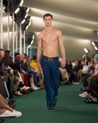 O modelo está usando calças de alfaiataria.