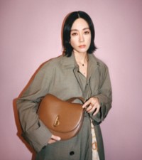 Asami holding Rocking Horse Bag in colour Hazel