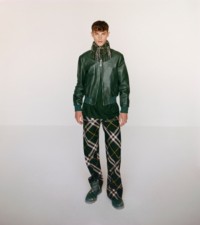 Model wearing the Leather bomber jacket, with jacquard shirt and zip trousers in ivy.