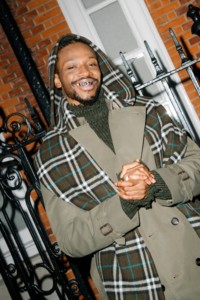 Photo de l'orateur Sosa portant un trench Burberry et une écharpe Burberry Check