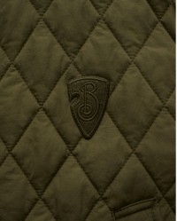 Nahaufnahme des B Shield-Details auf der Steppjacke von Burberry