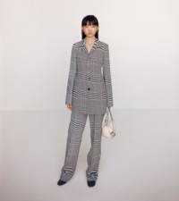 Model wearing Prince of Wales check wool jacquard tailored jacket in black and white, paired with the leather small Knight bag in soap.