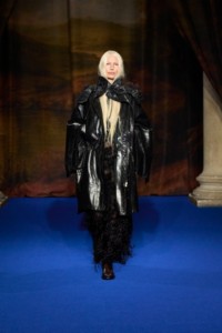 Kirsty Hume wearing faux fur trim leather parka cape in black, vine bead-embellished silk blend lace dress in black with leather cavalier boots in treacle brown.