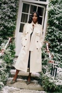 Photo du mannequin Naomi Campbell portant un trench Burberry, debout sur les marches devant une maison 