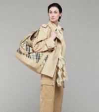 Modelo que luce chaqueta estilo trench coat, pantalones cargo y bolso bombonera Rocking Horse a cuadros Burberry Check