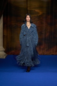 Haojie Qi wearing shredded baroque print viscose blend trench coat in ink blue and Leather Cavalier thigh high boots in treacle brown.