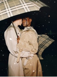 Casal usando trench coats Burberry e segurando guarda-chuva dobrável xadrez