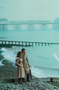 Trench coat Heritage da Burberry, imagem de um homem e uma mulher em pé na praia.