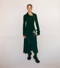 아이비 색상의 프린스 오브 웨일즈 비스코스 자카드 지퍼 드레스와 B 자수가 연출된 아이비 및 셔벗 색상의 가죽 체스 사첼을 착용한 모델.