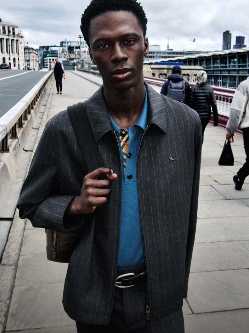 Persona che indossa la giacca Harrington Bloomsbury in lana gessata grigio Iron sopra una polo in lana blu Maritime