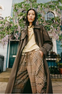 Donna che indossa pantaloni Burberry Check abbinati a un trench lungo in misto cotone