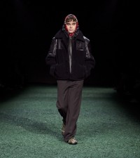Model in Leather panel herringbone wool jacket in black