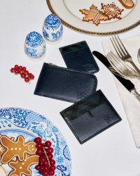 Shot of a Dining Table with two plates and in the middle three Burberry Wallets and Card Cases in Black