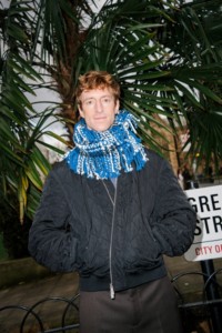 Shot of Artist Orfeo, wearing Check Cashmere Happy Scarf in colour Knight