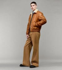 Modelo que luce chaqueta Harrington color arena, camisa Oxford y pantalones en pana
