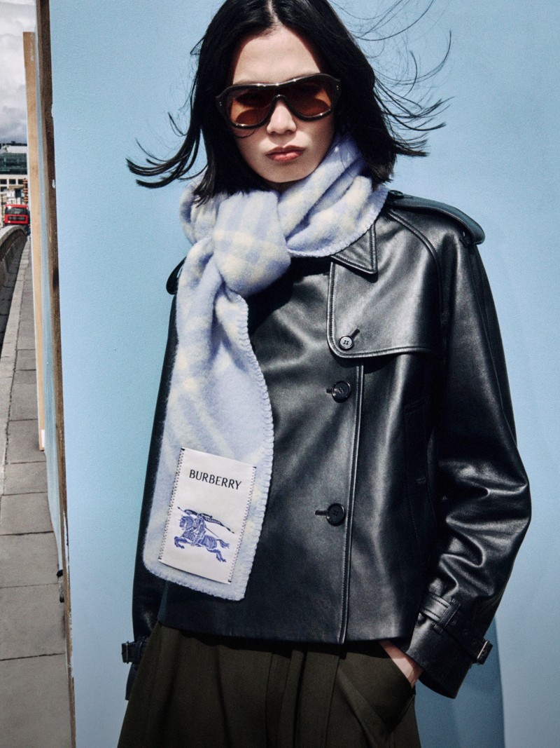 Shot of model wearing the Check Wool Scarf in colour Dive blue on top of the Cropped Leather Mayfair Trench Jacket in colour Black