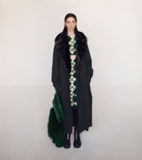 Una modelo luce un trench coat Kennington en algodón color onyx sobre unos pantalones en jacquard y falda color ivy.