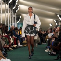 Model in Bluse, Shorts mit Knight-Ketten-Print und Pumps „London“ mit Reißverschluss