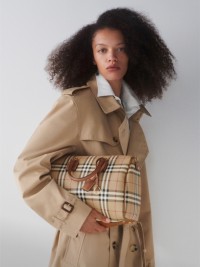 Model wearing Burberry Trench Coat while holding Large Check Bag.