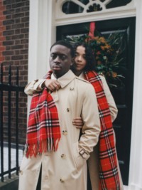 Casal vestindo trench coat Burberry e cachecol de cashmere em Check vermelho.