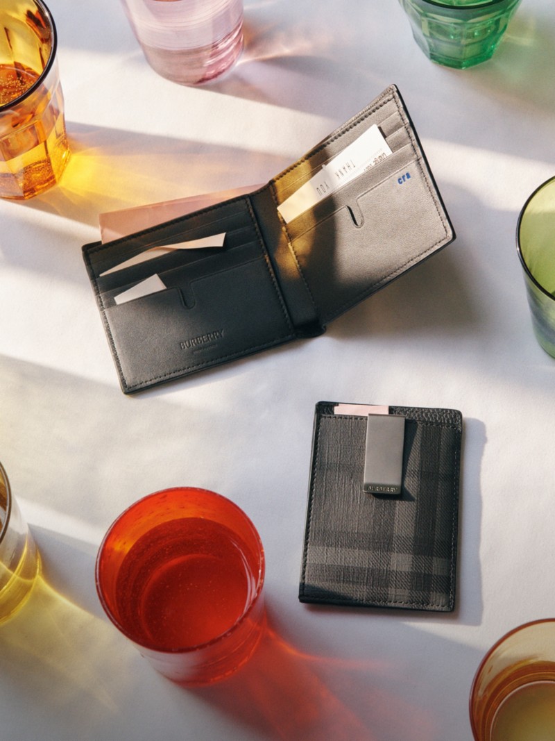 Shot of Burberry Wallets placed on a table, surrounding by drinking glasses