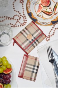 Shot of Burberry Check Wallets, places on a dining table with cutlery and glasses